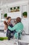 Carefree senior multiracial couple dancing in kitchen at home