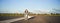 Carefree skater girl on her skateboard, riding longboard on an empty road, holding hands sideways and laughing