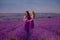 Carefree two beautiful women enjoying sunset in lavender field. Harmony. Attractive blond and brunette with long curly hair style