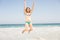 Carefree woman in bikini jumping on the beach