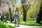 Carefree woman enjoys a bike ride through a lush green park embracing spring vitality