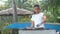 Carefree woman happily dancing while cooking fish in the garden.