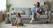 Carefree woman relaxing on couch while daughter playing on floor