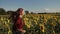 Carefree woman running through field of sunflowers