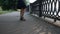 carefree woman is walking on embankment in city, closeup of feet, sandals and skirt