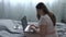 Carefree woman working on laptop on the bed