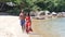 Carefree young couple vlogger filming video on camera while walking on the beach