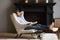Carefree young male resting in capacious armchair at luxury apartment