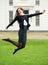 Carefree young woman jumping outdoors