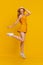 Carefree Youth. Positive Teen Girl Jumping Over Yellow Studio Background