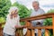 Careful couple standing on the bridge and placing heart deco on it