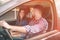 Careful driving. Beautiful young couple sitting on the front passenger seats and smiling while handsome man driving a