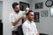Careful hairstylist is cutting the client\'s hair with scissors