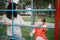 Careful woman fixing position of medical mask on girl`s face at playground