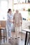 Caregiver assisting woman walking with crutches