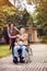 Caregiver daughter with senior man in wheelchair