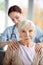 Caregiver doing massage for retired aged woman