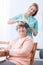 Caregiver doing senior woman\'s hair