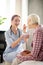 Caregiver feeding retired woman while giving her oatmeal