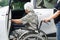 Caregiver help Asian elderly woman disability patient get in her car, medical concept