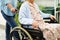 Caregiver help Asian elderly woman disability patient sitting on wheelchair in hospital, medical concept