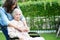 Caregiver help Asian elderly woman disability patient sitting on wheelchair in park, medical concept