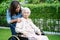 Caregiver help Asian elderly woman disability patient sitting on wheelchair in park, medical concept