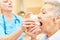 Caregiver helps senior citizen with inhaler