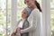 Caregiver hugging sick child with cancer wearing headscarf