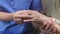 Caregiver massaging finger of elderly woman in painful swollen gout