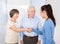 Caregiver shaking hands with senior couple