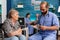 Caregiver support nurse reading book stories to senior disabled pensioner