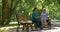 Caregiver talking to disabled senior woman in wheelchair outdoors