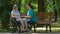 Caregiver talking to disabled senior woman in wheelchair outdoors