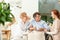 Caregiver talking to a smiling senior woman and her friend in th