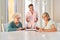 Caregiver watches seniors play dominoes