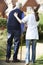 Carer Helping Senior Man To Walk In Garden Using Walking Stick