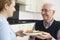 Carer Serving Lunch To Senior Man