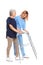 Caretaker helping elderly woman with walking frame on white