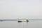 Cargo barge floating with gravel on the background of shoreline with forest.