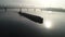Cargo barge floats on the river, morning haze, fog over the water.