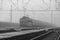 Cargo black and white electric train in Velky Osek station in mist morning