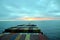 Cargo container ship sailing toward sunset on Pacific Ocean.