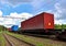 Cargo Containers Transportation On Freight Train By Railway. Intermodal Container On Train Car. Rail Freight Shipping Logistics