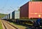 Cargo Containers Transportation On Freight Train By Railway. Intermodal Container On Train Car. Rail Freight Shipping Logistics.