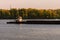 Cargo delivery by river transport. The tug boat towing an empty barge. Scenic morning autumn landscape of Kyiv. Nature landscape.