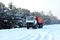 Cargo dump truck rides on a snowy road to load sand into career. Winter road against the backdrop of fabulous spruce trees