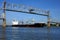 Cargo Freight Ship Sailing under Lift Span Bridge