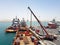 Cargo operations ongoing onboard supply vessel working for offshore platforms. Oil and Gas industry with vessels in background