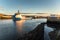 Cargo ship leaving a harbour at sunset